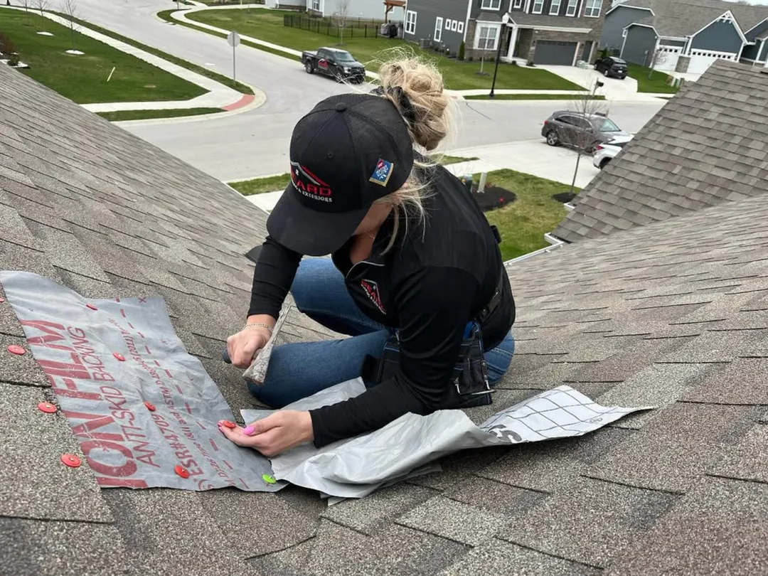 A crew member fitting underlayment on a residential roof