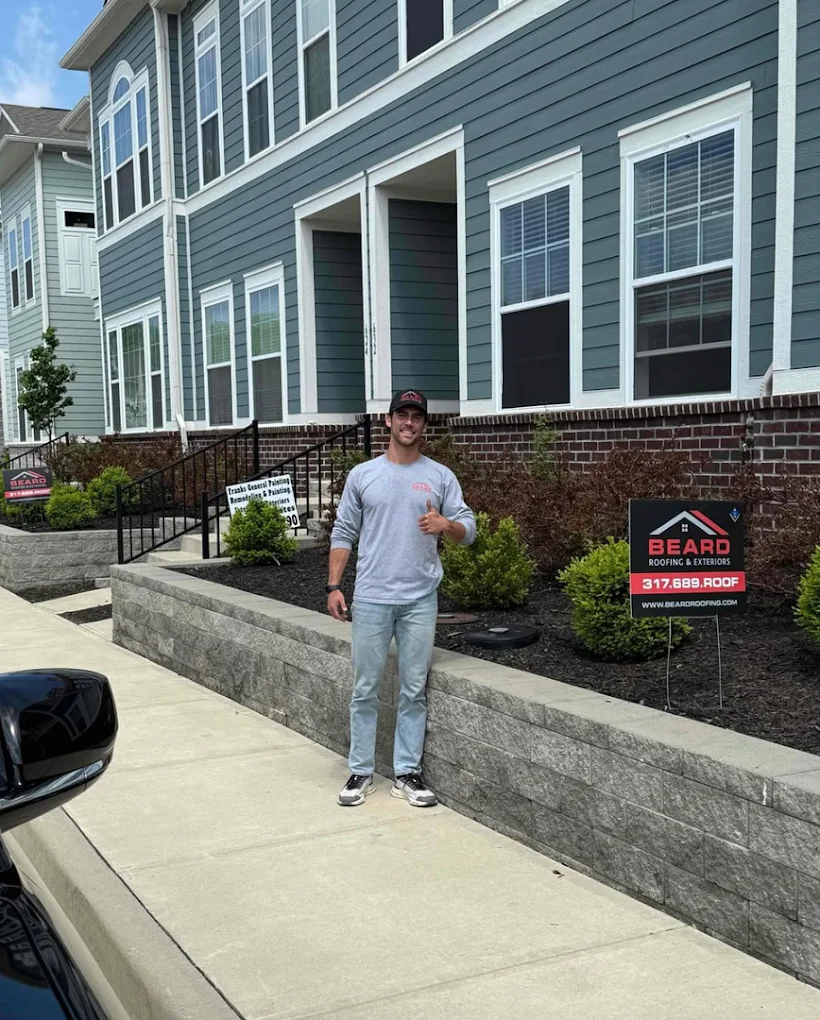 A team member outside a home with new siding